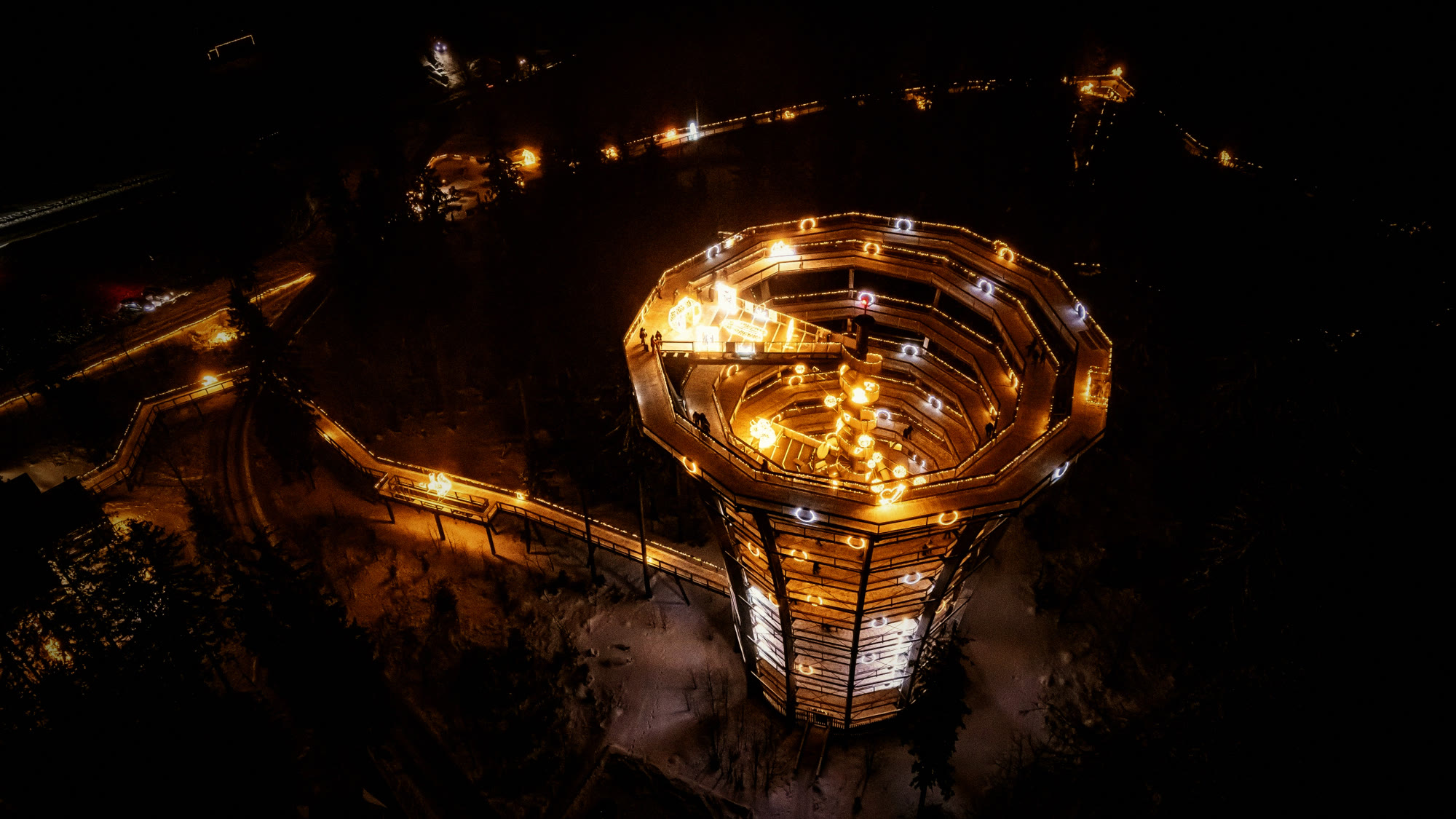 Lichterzauber — illuminated treetop walk observation tower, drone view (Salzkammergut)