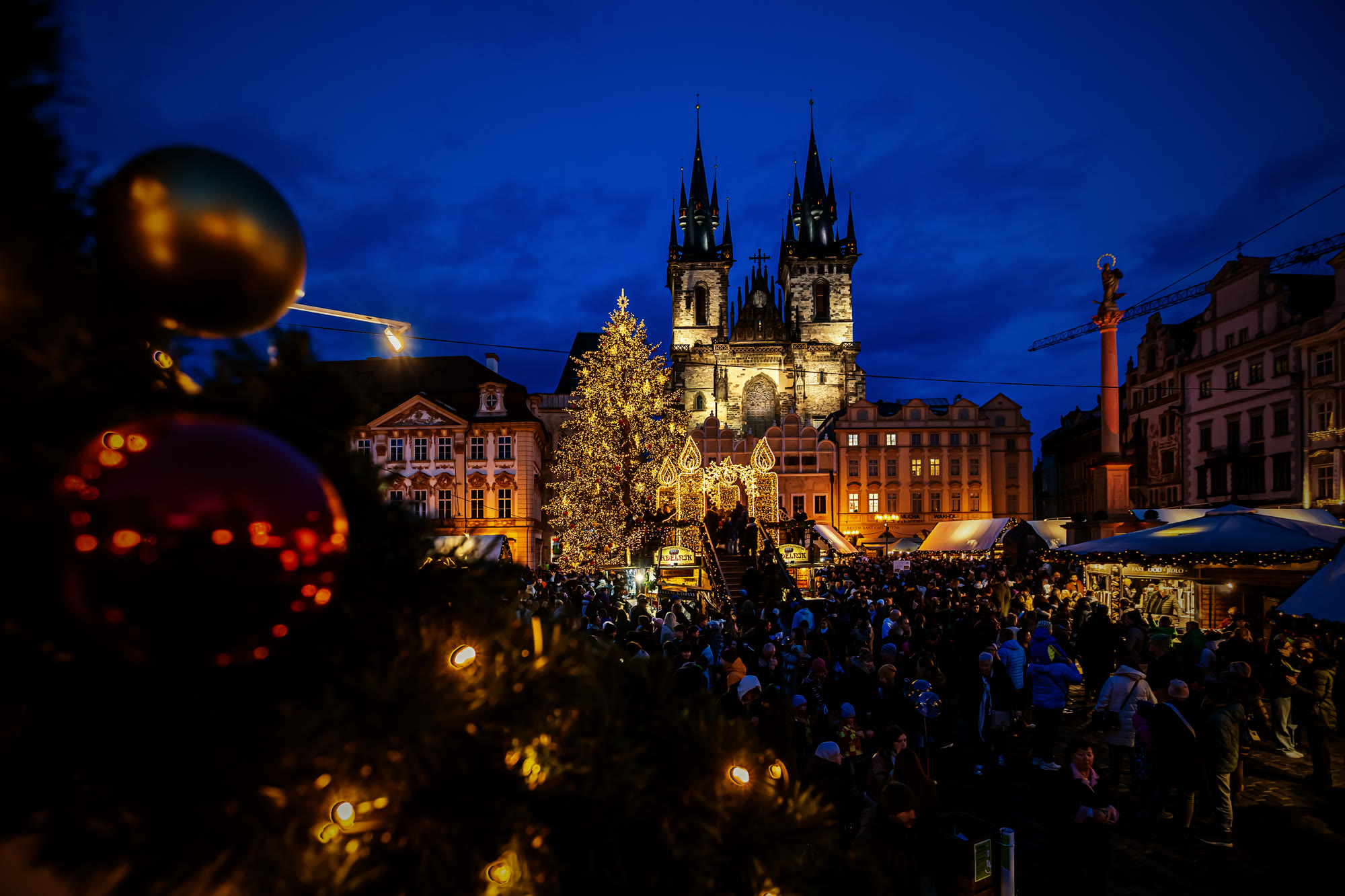 Prague Old Town Square — Tyn Church and Christmas markets at twilight, packed with visitors