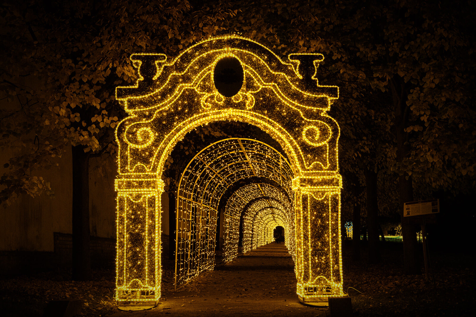 Royal Palace of Gödöllő — illuminated baroque arch leading into a corridor of light